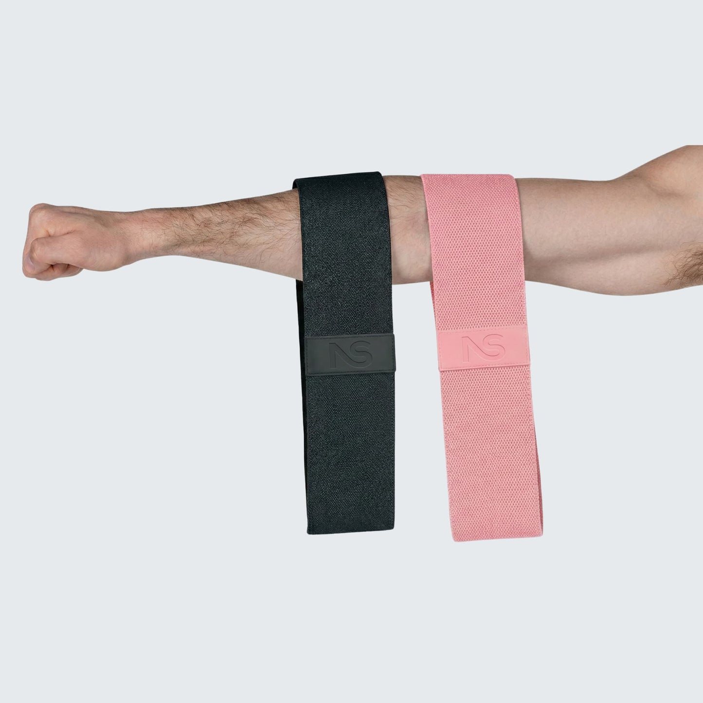 Utilisation des bandes de fitness Neosweat pour le renforcement musculaire des bras chez l'homme, montrant la polyvalence du produit.