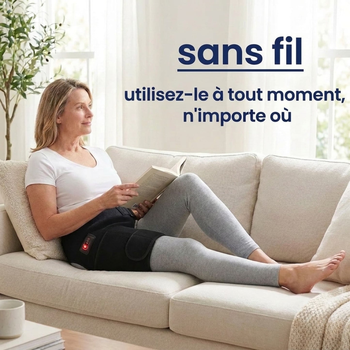 Femme relaxée lisant sur un canapé tout en portant l'attelle de hanche sans fil, utilisable à tout moment et n'importe où.