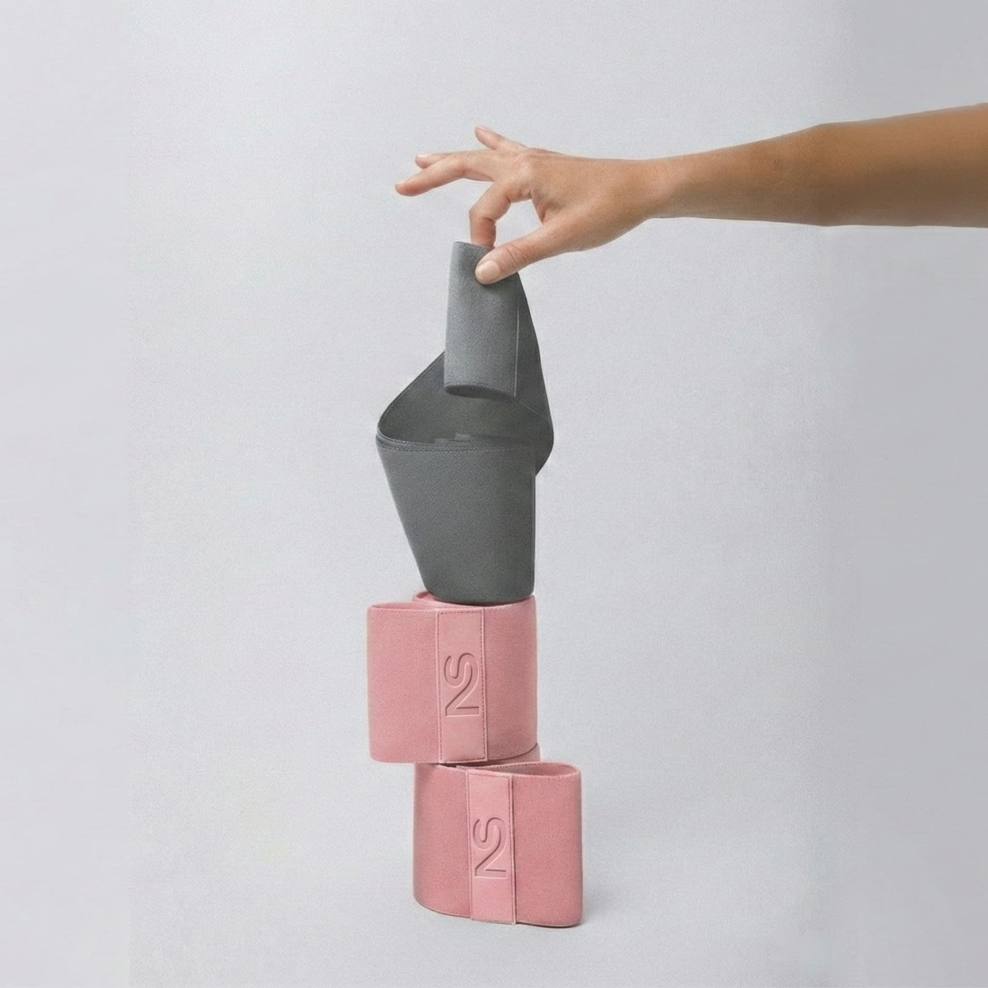 Démonstration de la compacité des bandes Neosweat pliées, idéales pour un sac de sport ou le home-gym.