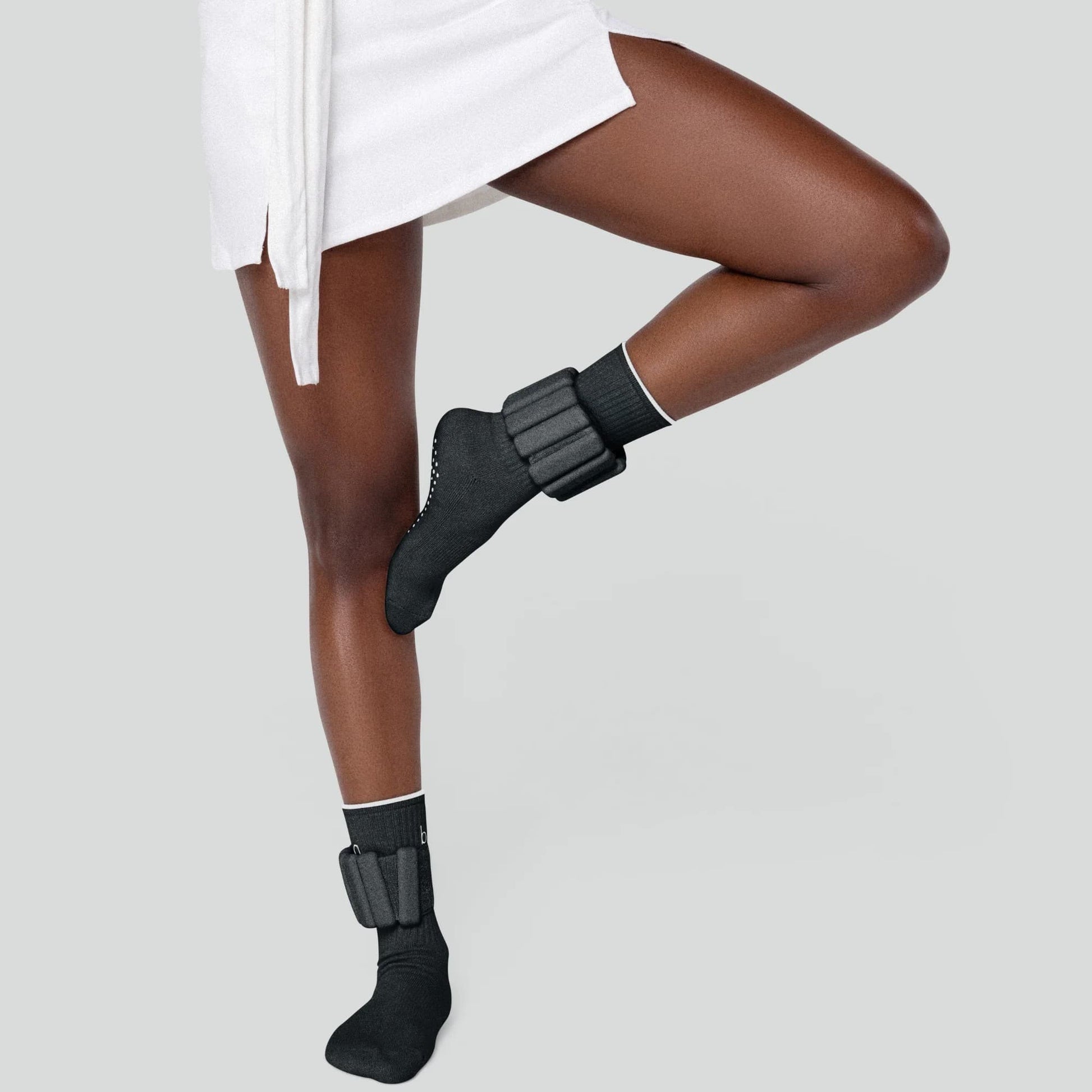 Gros plan sur le bracelet lesté noir Neo-Sweat porté au poignet, montrant le design ergonomique, la texture des matériaux et l'ajustement confortable.