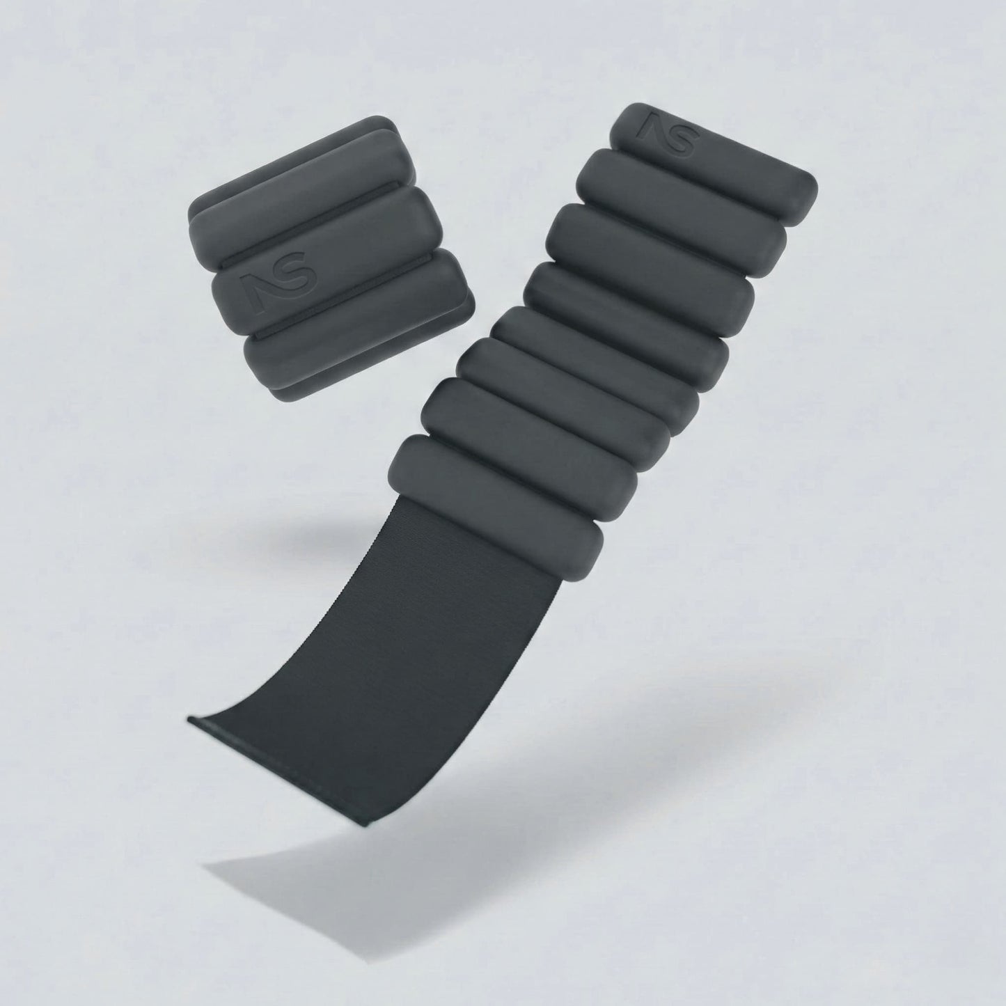 Bracelets lestés noirs Neo-Sweat en suspension, montrant la sangle réglable par scratch pour poignets et chevilles.