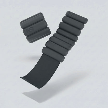 Bracelets lestés noirs Neo-Sweat en suspension, montrant la sangle réglable par scratch pour poignets et chevilles.