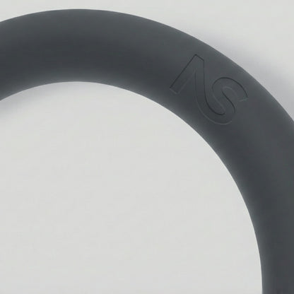 Gros plan sur la texture douce et le logo gravé sur le poids circulaire de fitness gris.