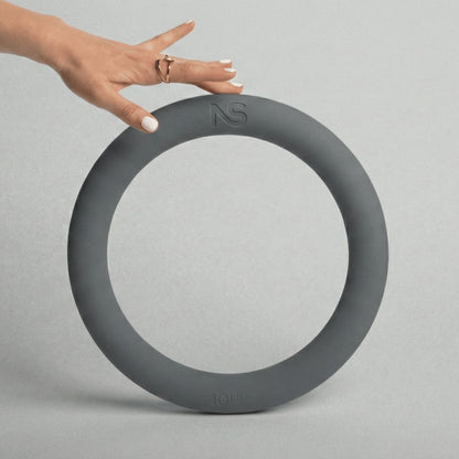 Main posée en équilibre sur le bord supérieur d'un anneau de musculation gris de 4,5 kg, permettant d'apprécier ses dimensions et sa prise en main.