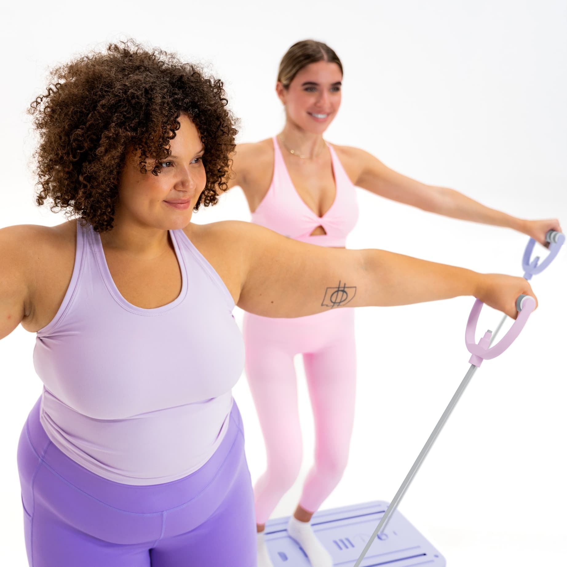 Deux femmes s'entraînant avec les bandes de résistance de la planche de Pilates Neo Sweat pour un renforcement musculaire.