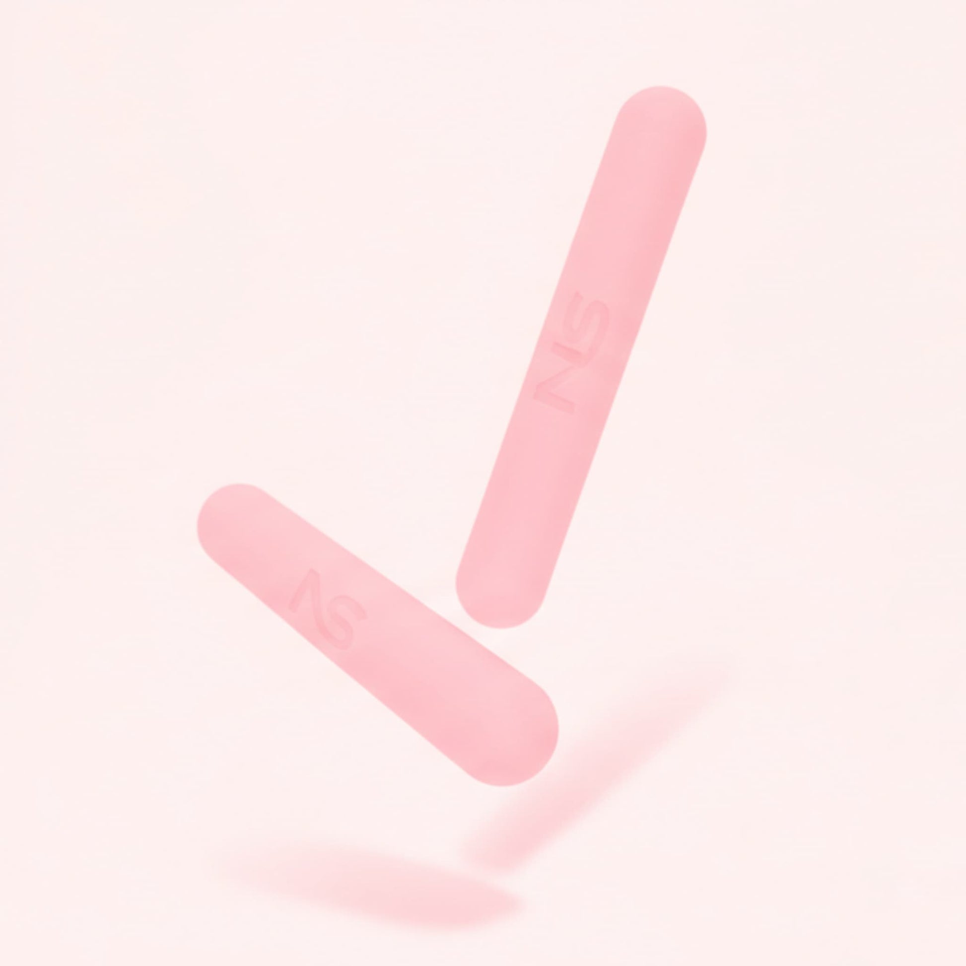 Deux haltères roses Neo Sculpt Bars en lévitation sur fond rose, montrant leur design cylindrique épuré pour le sport à la maison.